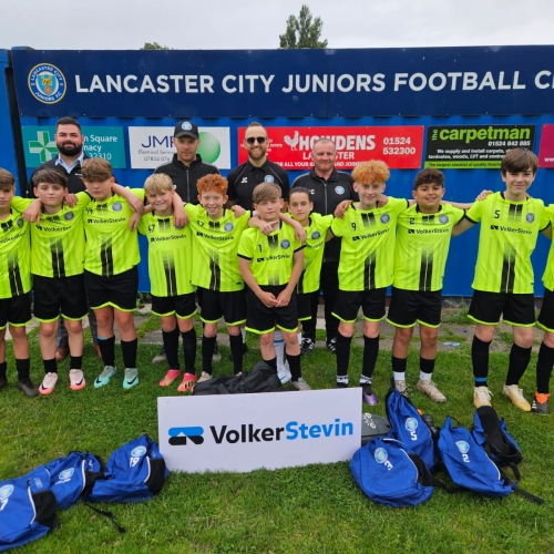 Football team with yellow kits stood outside.