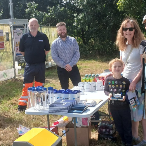 People stood around a table smiling.