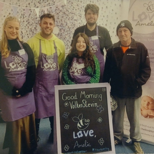 Five people stood in a baby bank charity.