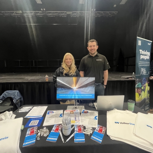 Man and women stood behind table with brochures and leaflets on