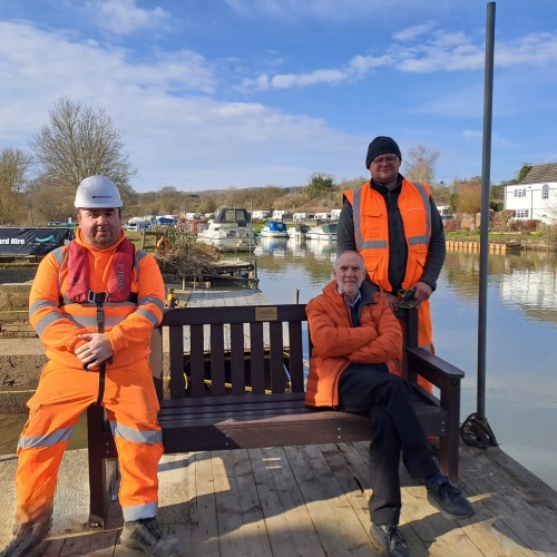Picture of three men sat on a bench.