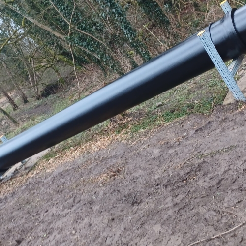 Picture of a black pipe in the woods.