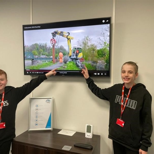 Two young boys pointing at a screen