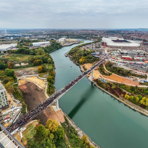 Keel Crossing opening - aerial image of bridge across the River Wear with large group of people walking across it
