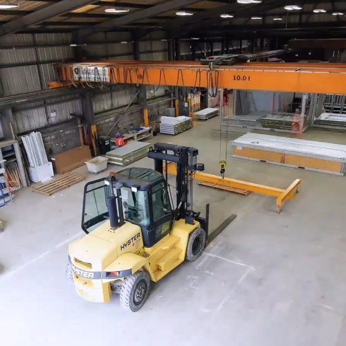Picture of a forklift placing sit cabins in a wharehouse.