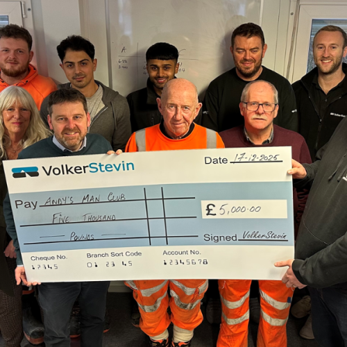 People stood around a giant check.