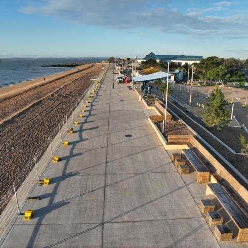 Promenade with beach and see to the leaf of the photo, blue sky