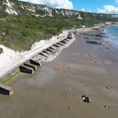 Picture of people stood on a beach.