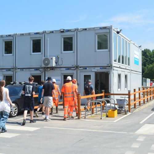 People walking into an office on a construction site.