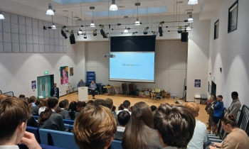 Engineers giving a presentation in front of a school.