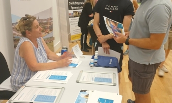 Students talking to a woman at a careers fair.