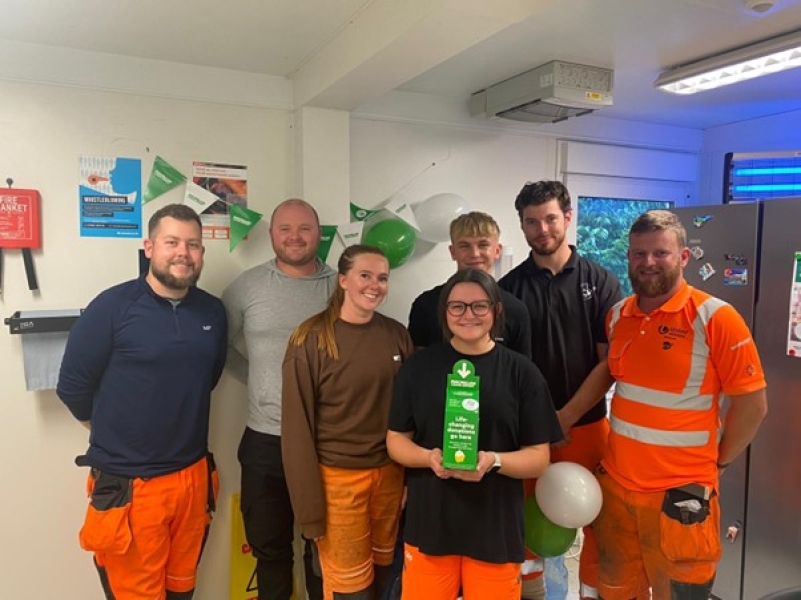 Group photo of men and women in orange hi vis workwear