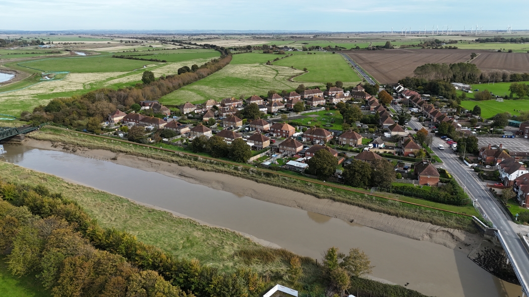 Picture of a river running in front of houses. Rother Tidal Walls 