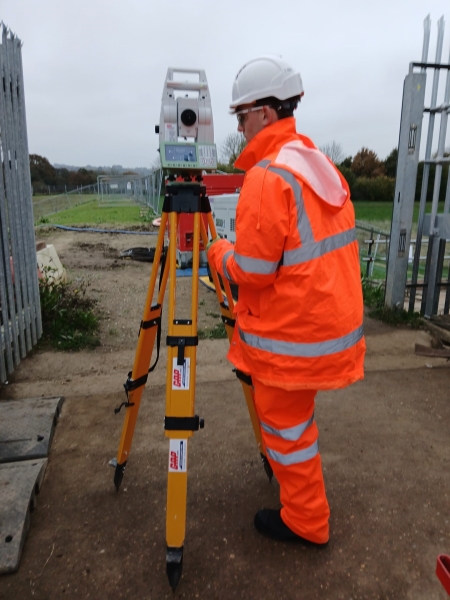 Person in PPE on site with a laser.