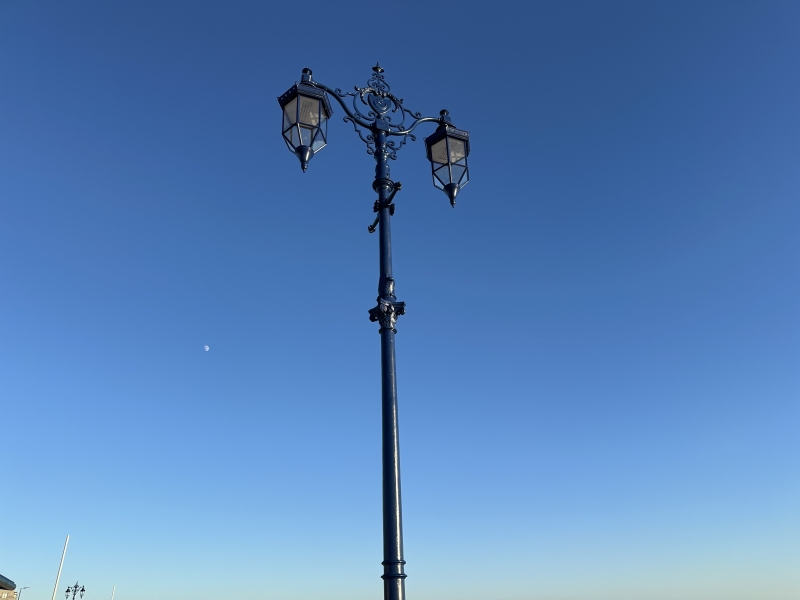 Restored old Victorian lamppost in black with two lamps either side