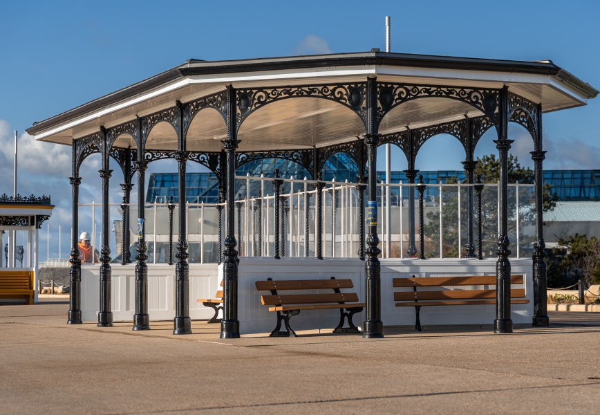 open shelter with bench seating around it painted black