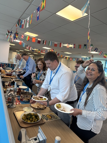 Men and women stood at a buffet in an office
