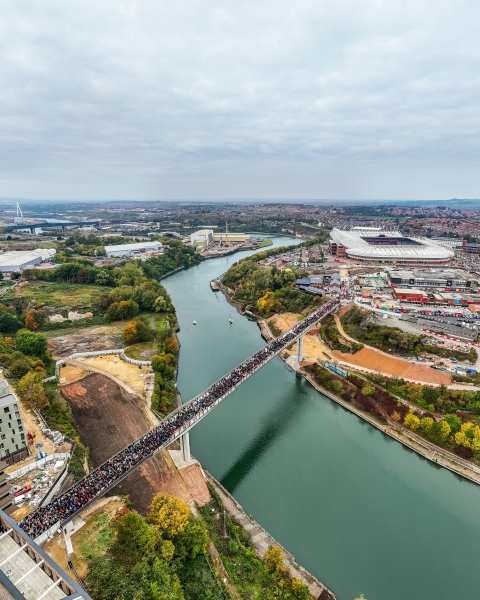 Keel Crossing opening - aerial image of bridge across the River Wear with large group of people walking across it