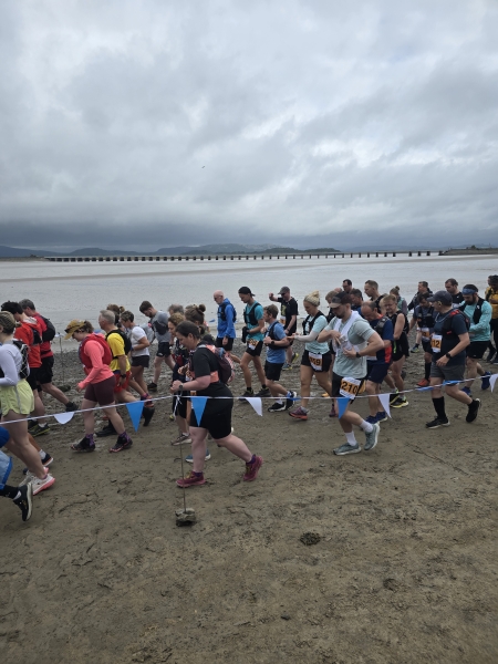 large group of people running on a beach