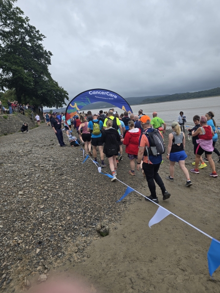 people on a beach running through a curved banner