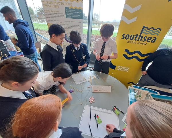 Children at the STEM fair undertaking an activity where they are building structures out of spaghetti and marshmallows.