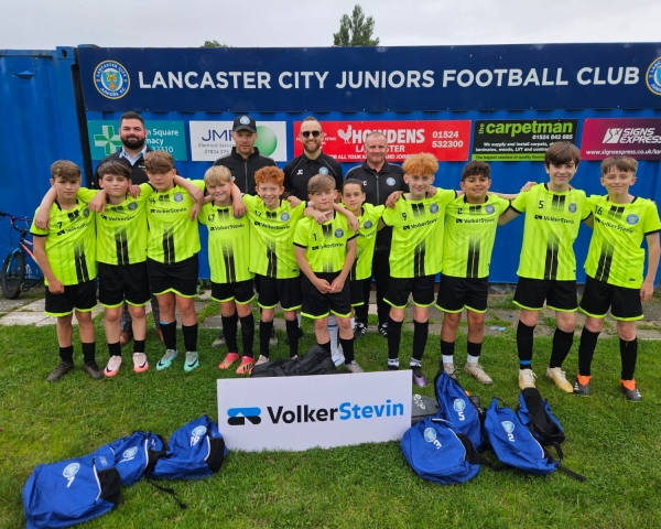 Football team with yellow kits stood outside.
