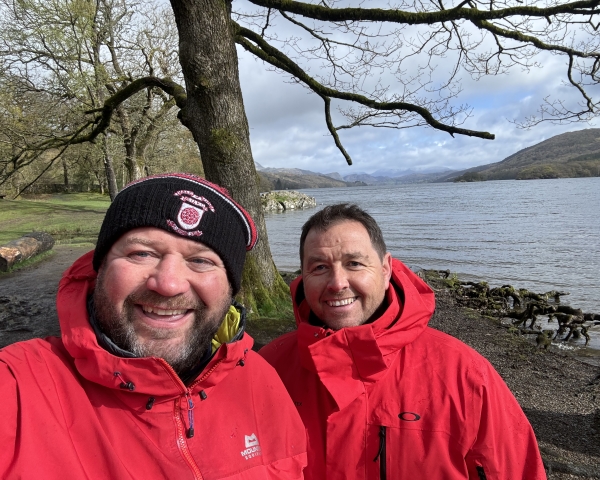 Two people stood in the woods smiling.