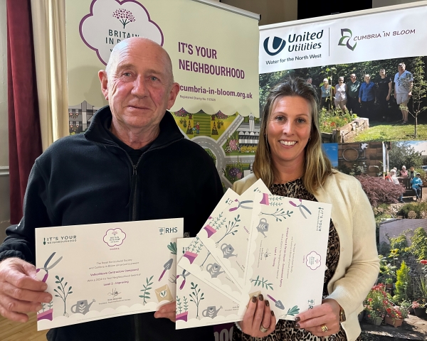 Man and women stood together holding certificates