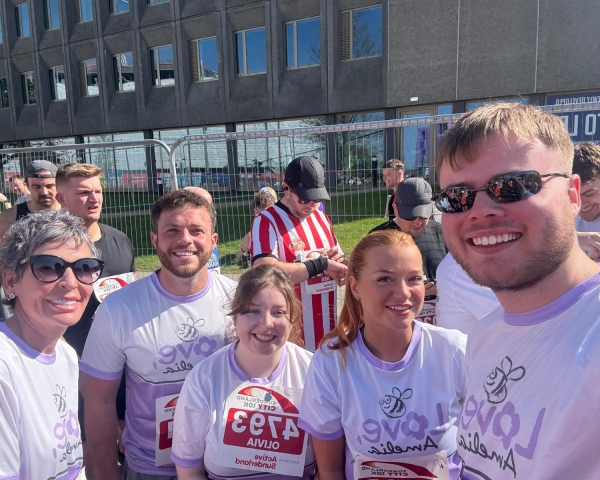 Picture of five people smiling in the sun