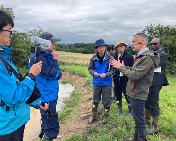 Picture of people being filmed in a field.