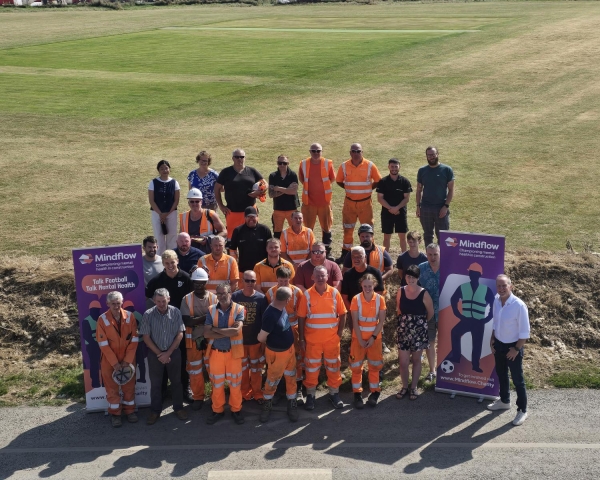 People stood outside next to a banner for a mental health event.