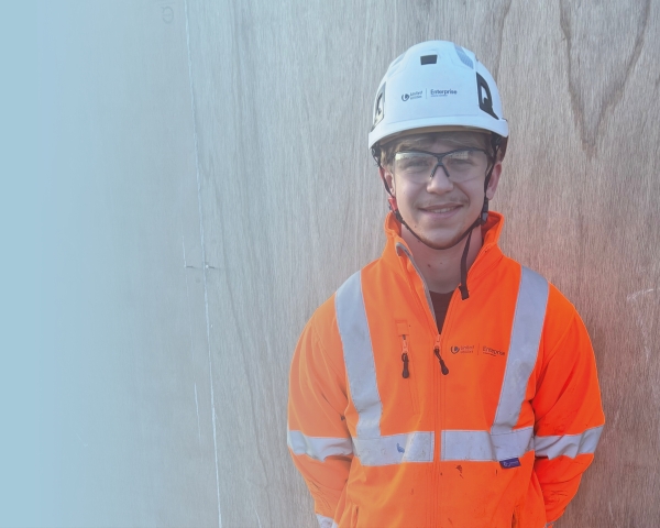 Picture of boy in high-vis smiling at the camera.
