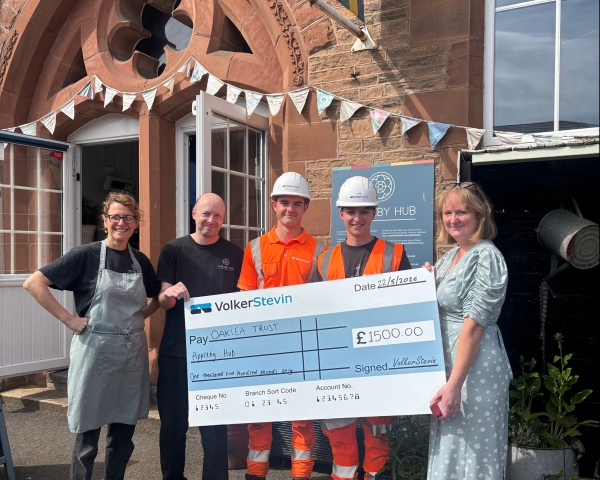 People with giant cheque presenting it to a charity.