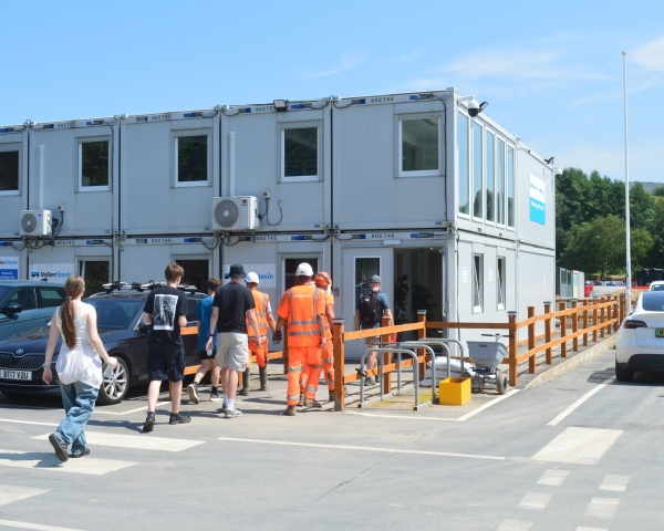 People walking into an office on a construction site.