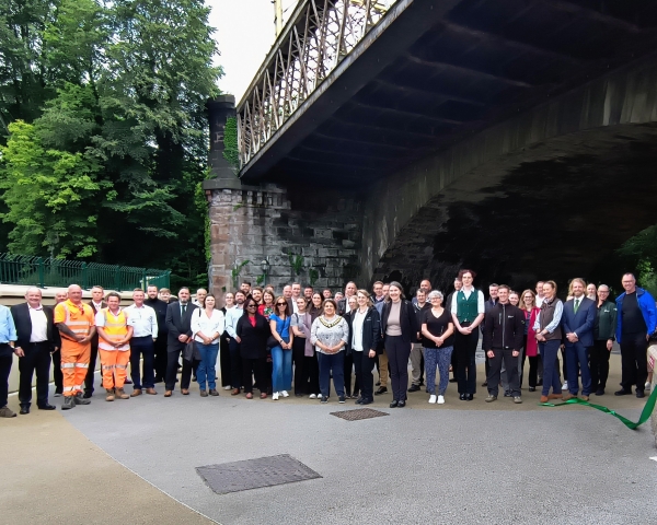 People stood in a group under a bridge.