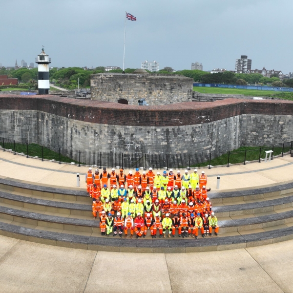 People in highvis sat on the steps of the Southsea Coastal Scheme.