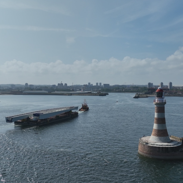bridge section on barge travelling on water out of a port