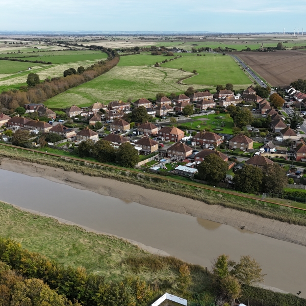 Picture of a river running in front of houses. Rother Tidal Walls 