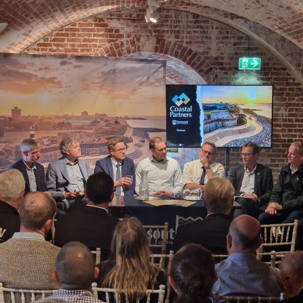 People sat around a table in front of an audience