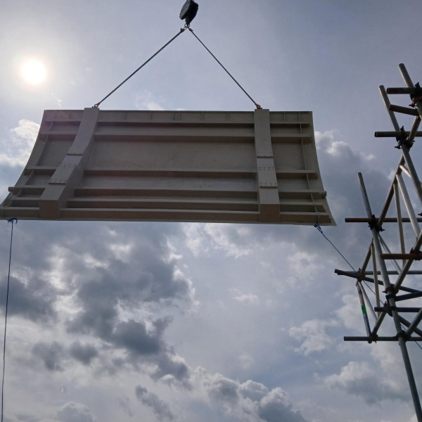 Flood gate being suspended in the air close to scaffolding
