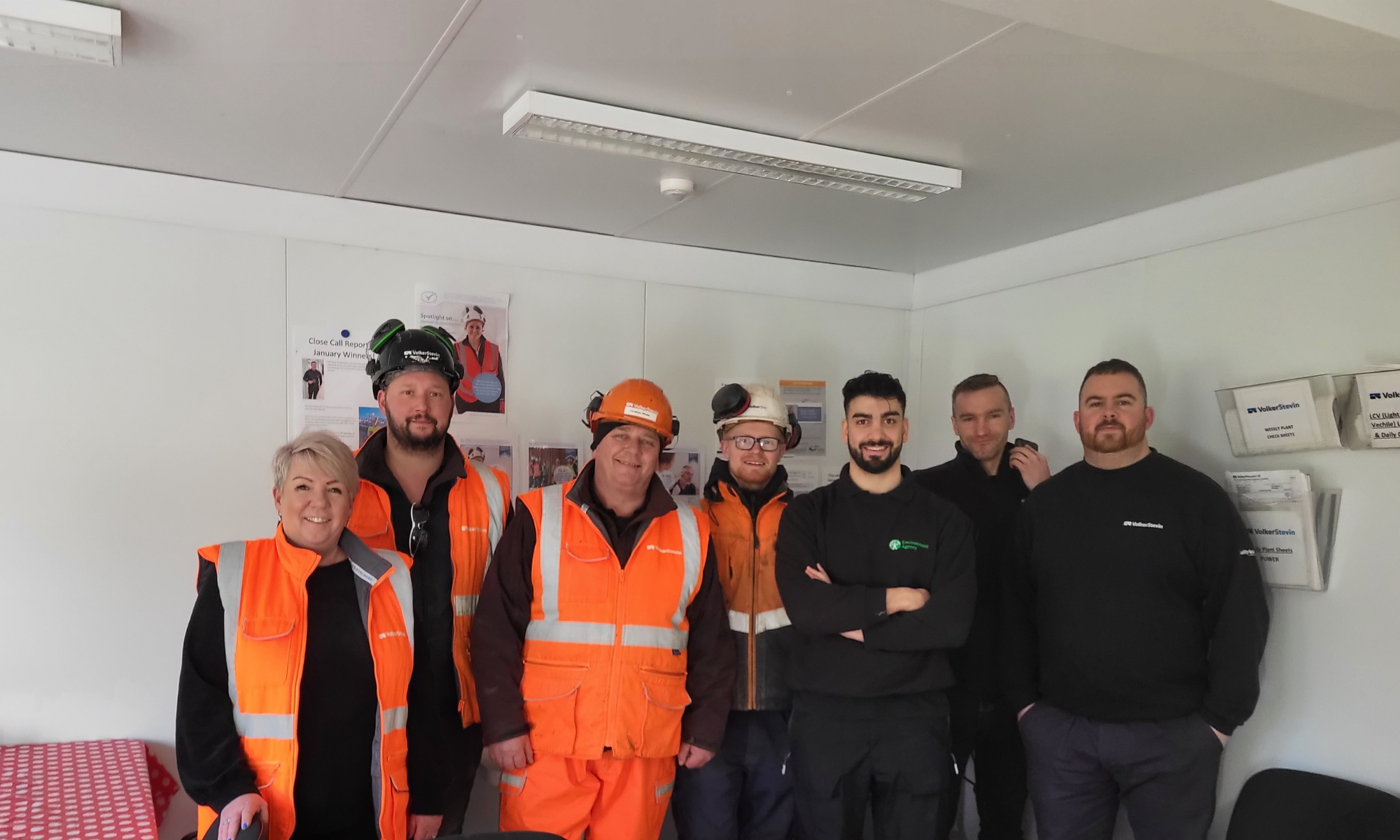 Group picture of men and women with some in orange hi-vis wear 