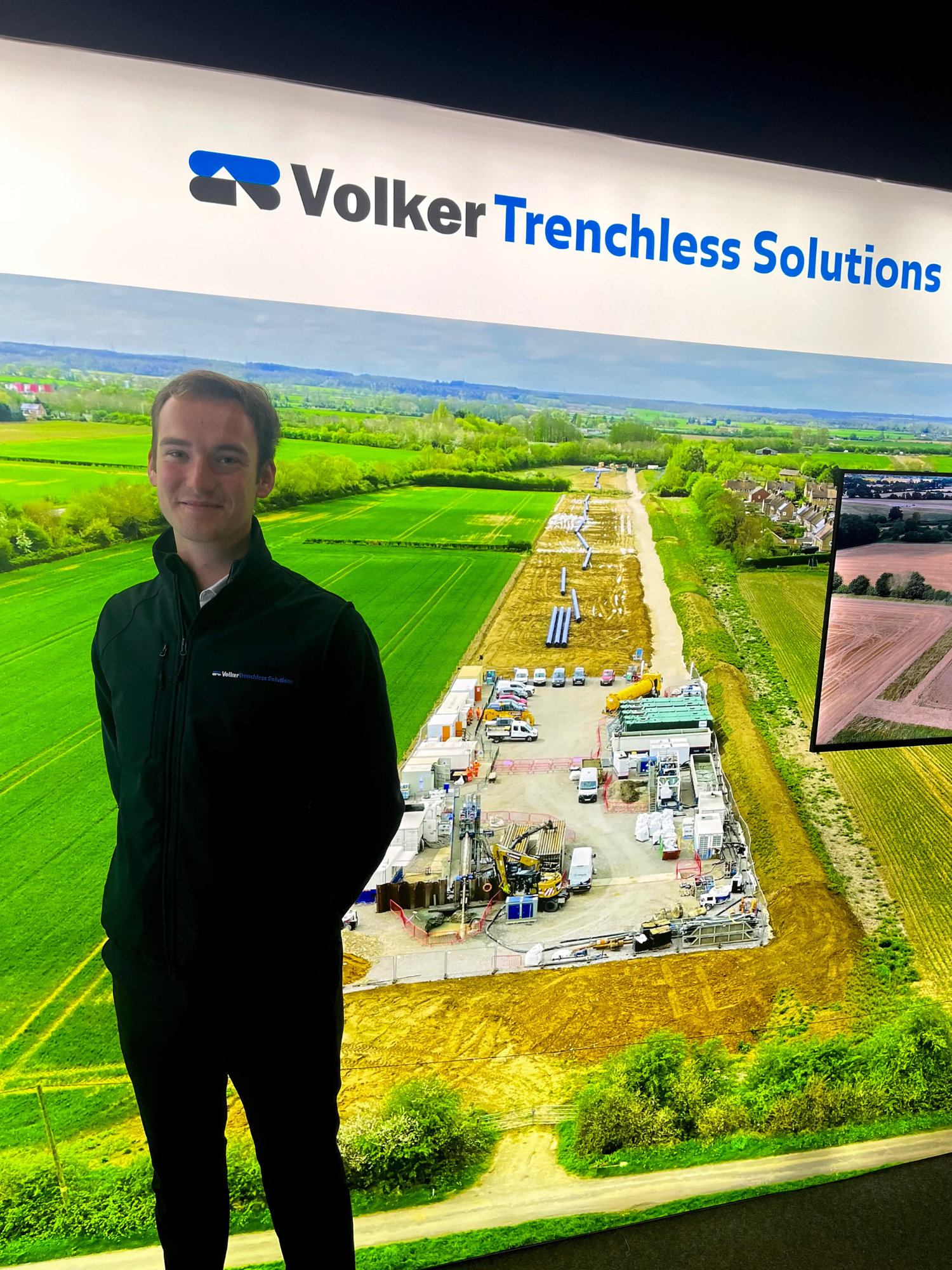 Adam Parkinson, Apprentice QS, stood in front of the VTS stand at No Dig 2024