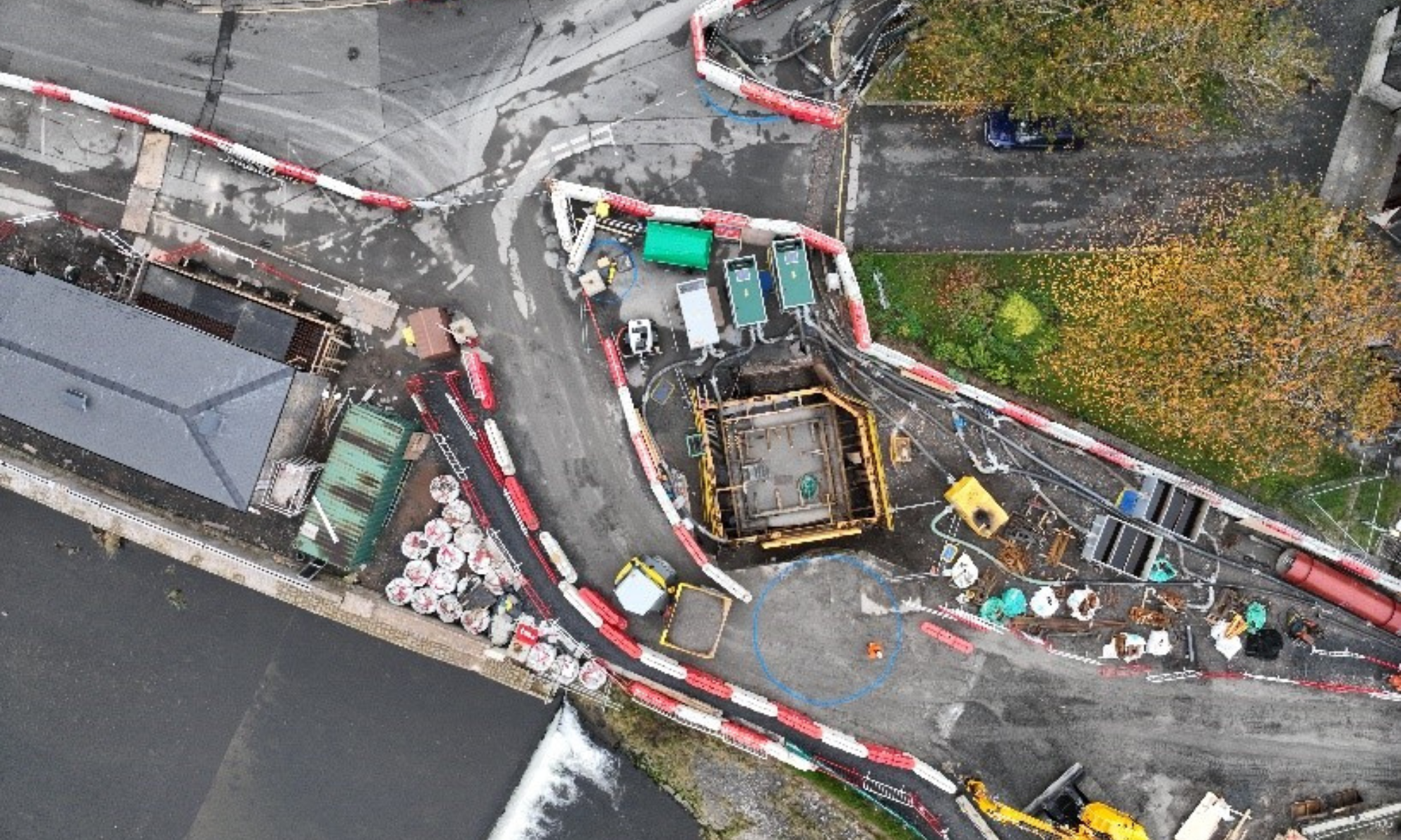 Aerial image of sewer upgrade with red and white barriers around it