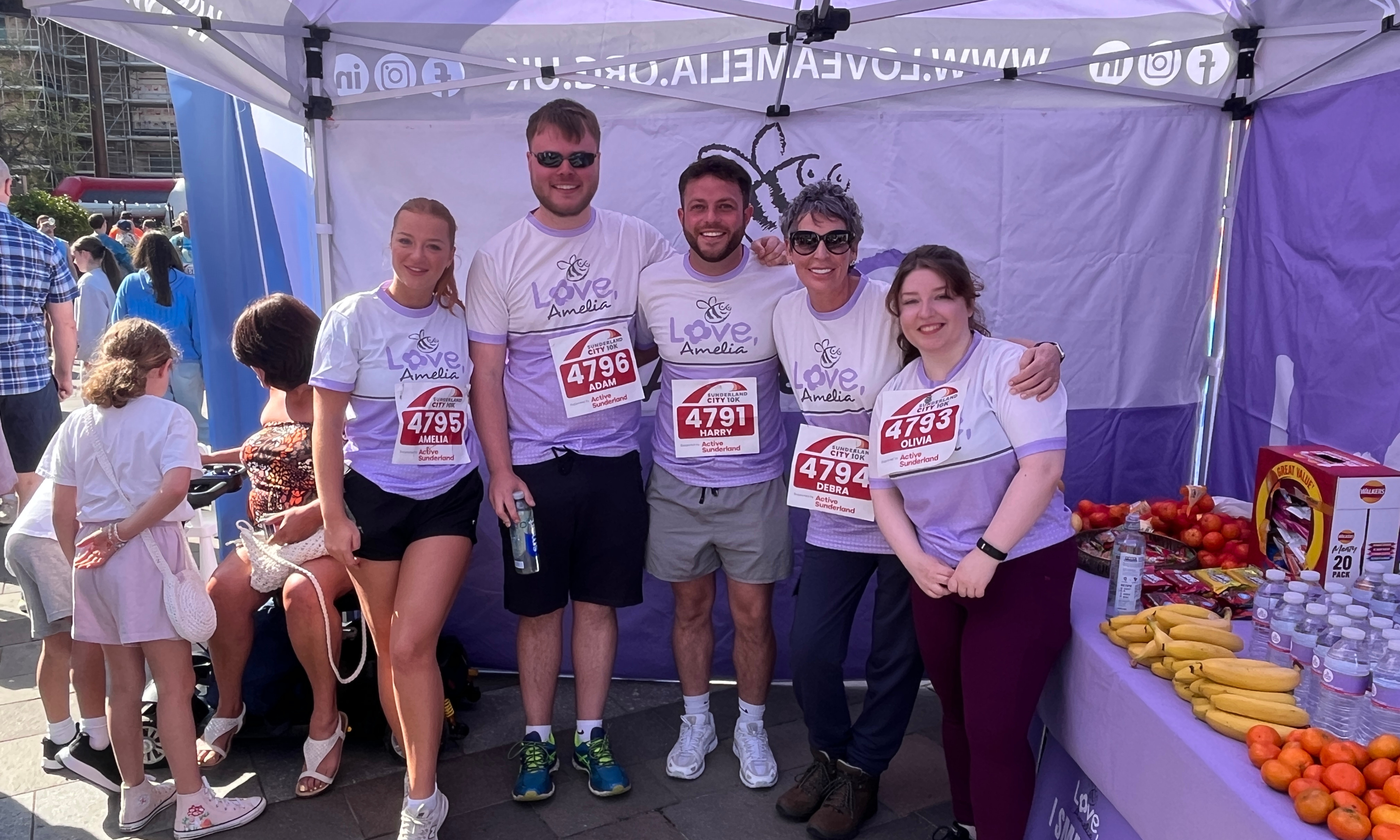 five people smiling in a tent.