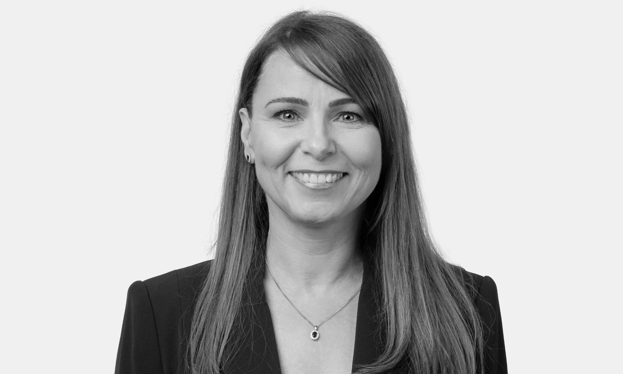 Picture of a woman smiling at the camera in black and white.
