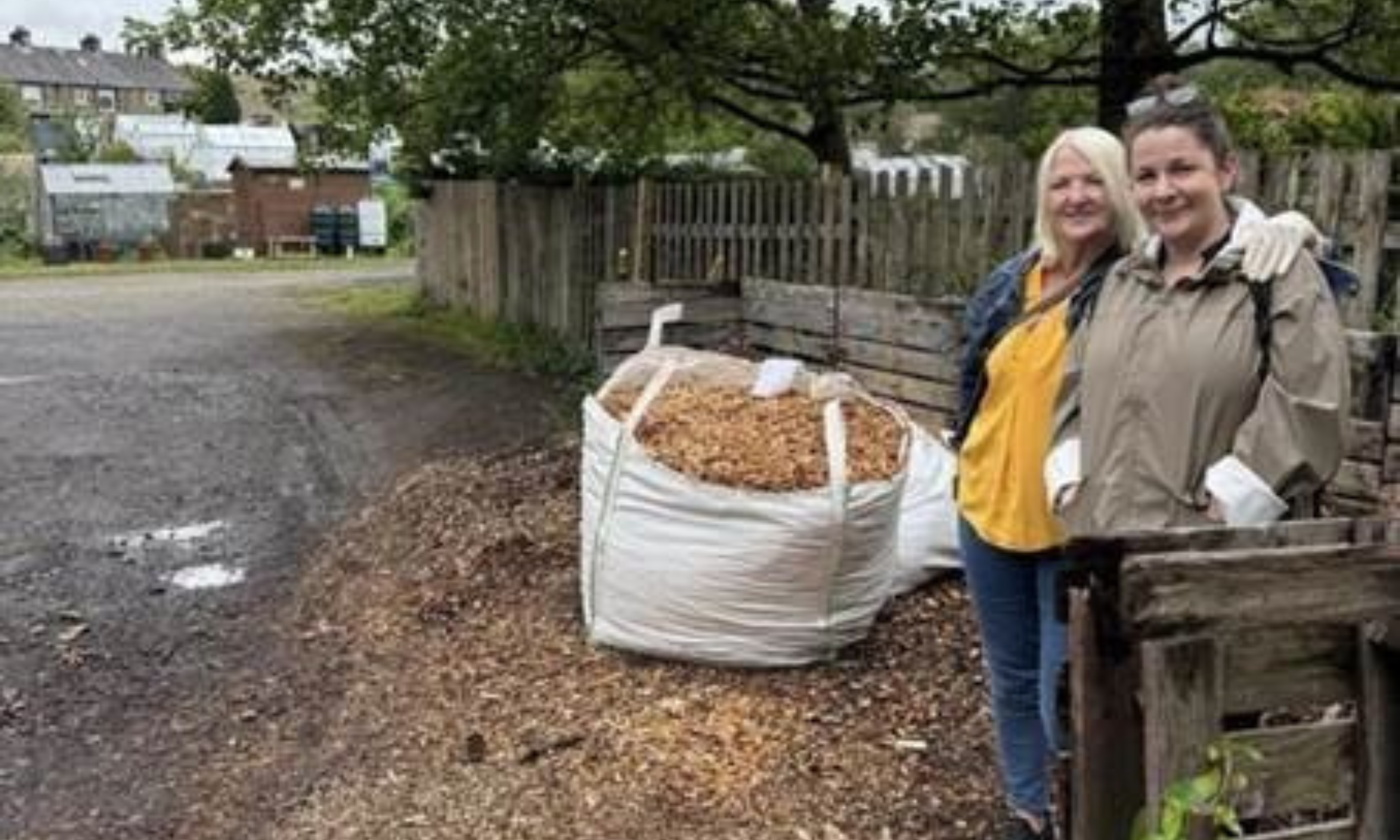 People stood next to wood chippings.
