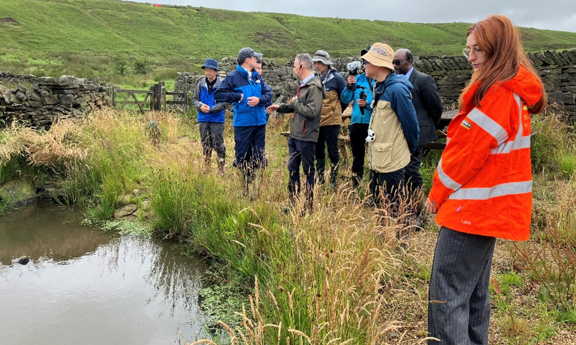 Picture of people being filmed in a field.