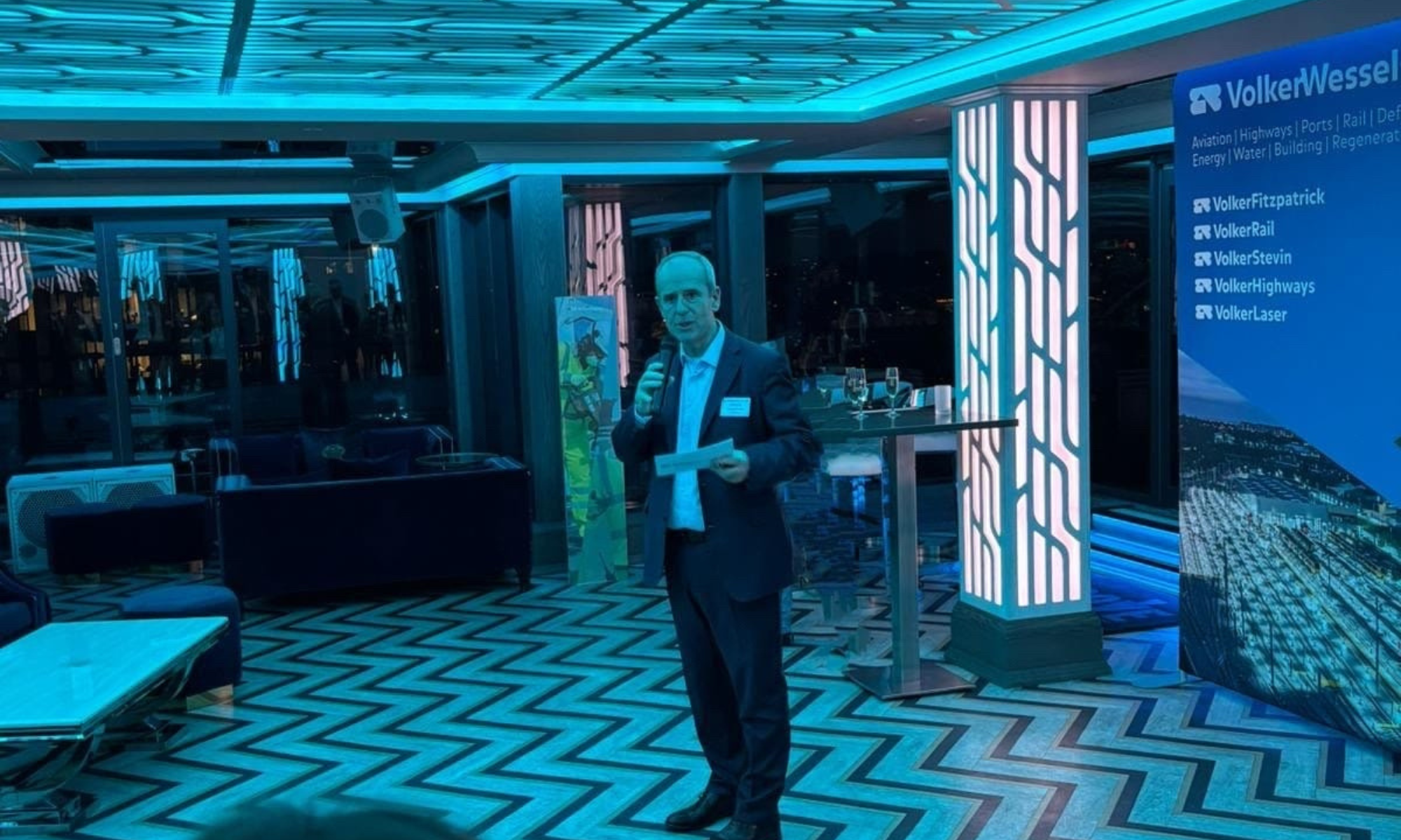 Man in a suit stood presenting 