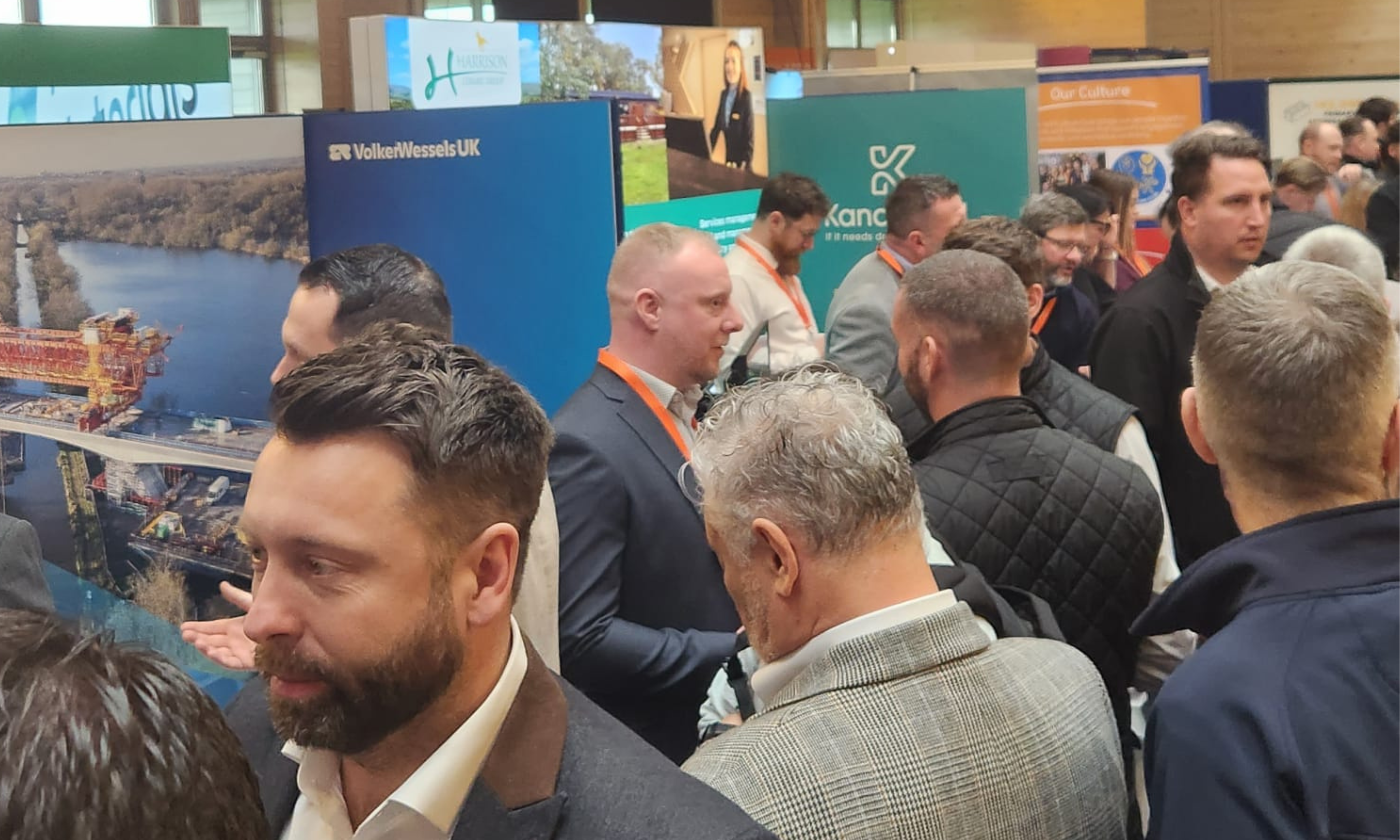 crowd of people in a large exhibition area with exhibition stands
