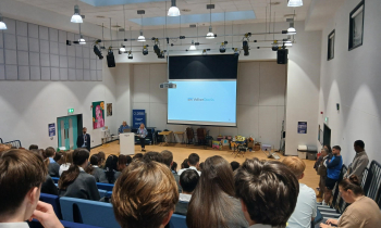 Engineers giving a presentation in front of a school.